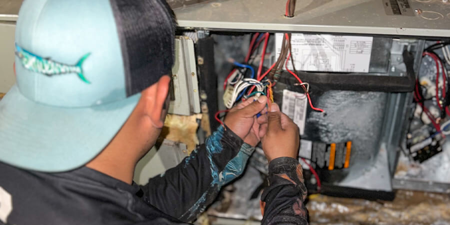 Service technician inspecting wires in heater